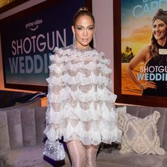 Zur Afterparty ihres neuen Films "Shotgun Wedding" trägt Jennifer Lopez einen angesagten Look in Glitzeroptik. Ihr Kleid mit Rüschen und Strasssteinchen passt perfekt zu ihrer glitzernden Netzstrumpfhose. Dazu kombiniert sie angesagte Plateau-Heels. 