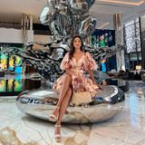 Verona Pooth liebt es außergewöhnlich und verspielt und zeigt das gerne auch während des Megaevents in Dubai. In der Lobby des neuen Hotels sticht sie im rosa Blümchenkleid mit integriertem Gürtel und mit cremefarbener Chanel-Tasche am Arm aus der Masse hervor.