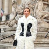Schauspielerin Philippine Leroy-Beaulieu bei der Schiaparelli Haute Couture Frühling/Sommer 2023 Fashion Show in einem langem Mantel. Die plüschige Jacke mit eingearbeiteter Corsage trägt der "Emily in Paris"-Star mit goldenen und schwarzen Accessoires.