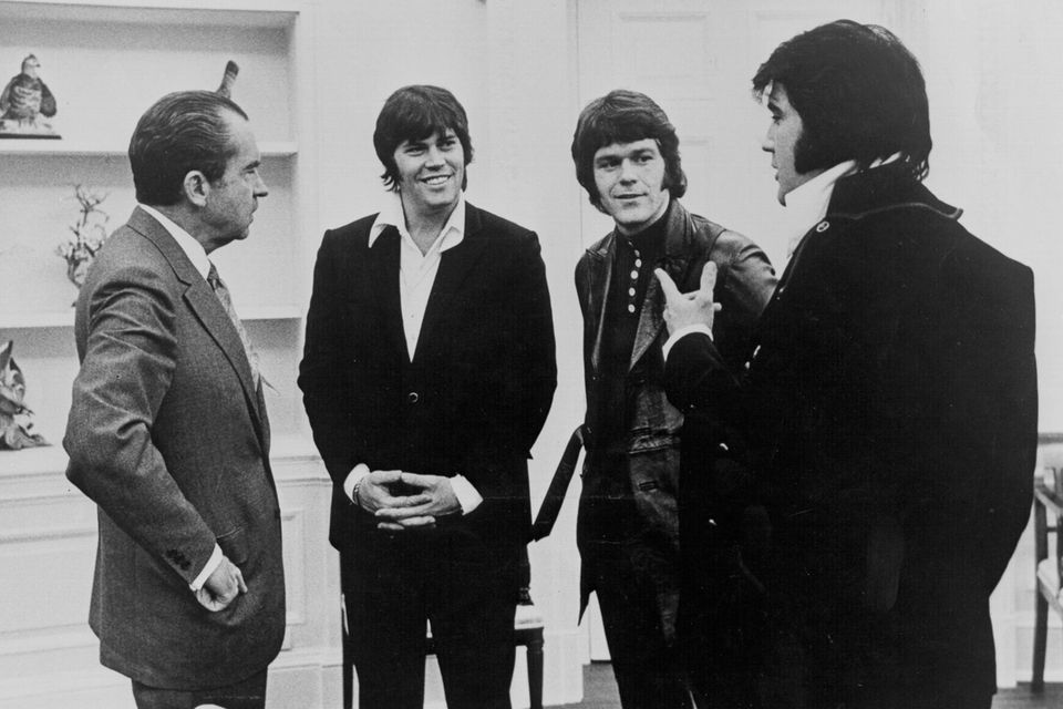 1970 besucht Elvis Presley (ganz rechts) zusammen mit Sonny West (2. v. l.) und Jerry Schilling (3. v. l.)  Präsident Richard Nixon (ganz links).