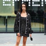 Auch Iman Perez gehört zu den vielen Stargästen der Chanel-Show. Im kurzen Paillettenkleid und Schleifenpumps des Labels vereint sie Glamour und 60s-Style.