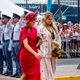 Tag 4  Die niederländische Königsfamilie ist auf Aruba angekommen! Königin Máxima glänzt in einem feuerroten Cape-Kleid und passendem Hut mit XL-Krempe, Prinzessin Amalia besticht in einem gestreiften Hosenanzug.