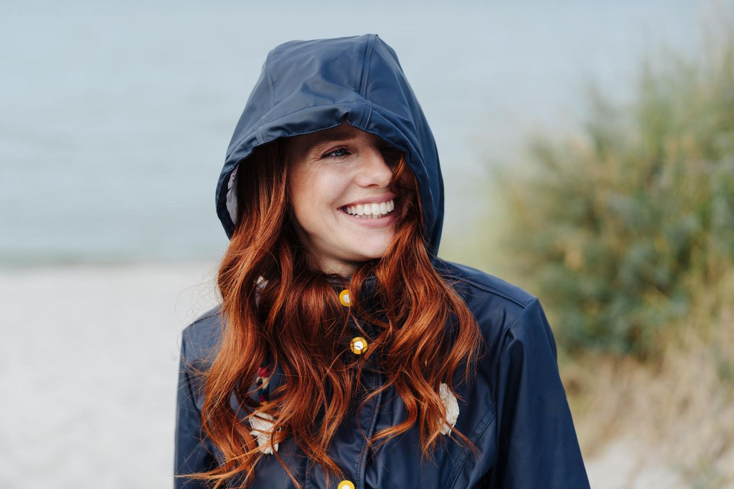 Deals des Tages: Lange Regenjacke von Only 40% reduziert, lachende Frau mit Regenjacke
