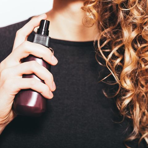 Frizz adé: 5 einfache Tipps gegen krause Haare, Frau mit Locken und Spray