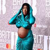 Und Babybauch Nummer drei! Auch Sängerin Kamille zeigt ihren Bauch der Öffentlichkeit. In einem petrolfarbenen gewickelten Dress mit Kapuze, bei dem die Bauchpartie ausgespart ist, besucht sie die Brit Awards 2023.