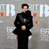 Genderneutrales Dressing at its best! Harry Styles rockte den Red Carpet der Brit Awards 2023 in einem schwarzen Anzug mit Schößchen in der Taille und einer riesigen Blumenhalskette. 