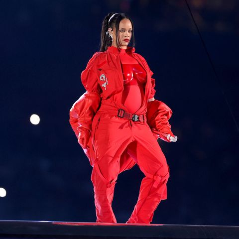 Sie macht Rot zu ihrer Farbe: Sängerin Rihanna trägt für ein Medley ihrer besten Hits zur Halbzeitshow des Super Bowls einen Einteiler von Loewe, worüber sich das passende Bustier verbirgt. Der Gürtel, der leicht über ihrer Hüfte sitzt, verdeutlicht ihre freudigen Neuigkeiten noch einmal stärker: Rihanna erwartet ihr zweites Baby. Aber auch die kurze Daunenjacke von Alaïa verleiht ihren Baby-News den richtigen Rahmen. Motto: Freie Sicht auf den Bauch! Doch ...