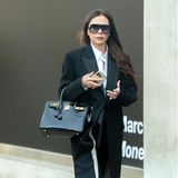 Victoria Beckham bleibt mit diesem Look in ihrer gewohnten Farbfamilie und setzt auf Wollmantel und weißes Hemd. Knallrote Heels mit graphischem Absatz verleihen dem Look der Designerin eine edgy, aber dennoch sexy Komponente.