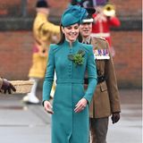 Bei der jährlichen Parade zum St. Patrick's Day in Aldershot begeistert Kate in einem schicken blaugrünen Mantelkleid von Catherine Walker und führt damit eine jahrelange Tradition fort. Seit ihrem ersten Auftritt beim irischen Nationalfeiertag setzt die Princess of Wales auf Mantelkleider in Grün. Dennoch ist dieser Auftritt eine Premiere, denn Kate ist neuerdings Colonel des 1. Bataillons der Irish Guards. Sie ehrt den irischen Nationalpatron "St. Patrick" mit riesengroßem Kleeblattanstecker. 