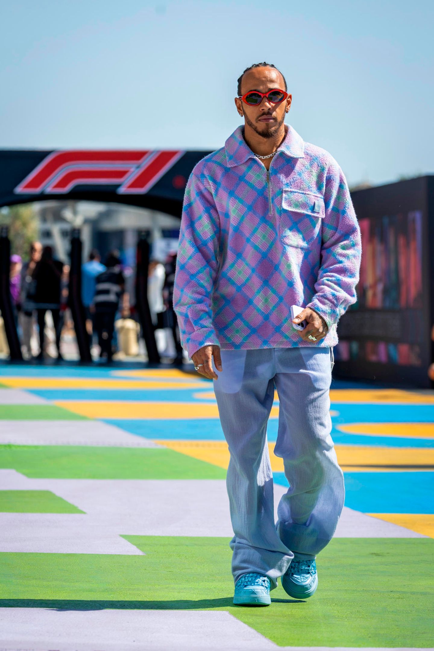 Bei diesem Look passt einfach alles – selbst der Boden! Beim Training für den Großen Preis von Saudi-Arabien zeigt sich Lewis Hamilton gewohnt stylisch. In einem karierten Dior-Esemble in pastelligem Lila läuft er auf dem ebenfalls pastelligen Teppich mit Schachbrettmuster und verwandelt ihn damit direkt zu seinem persönlichen Laufsteg.