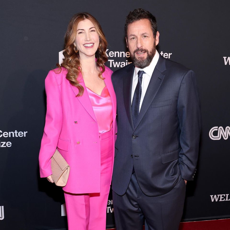 Er kann auch ganz schön seriös! Adam Sandler verkörpert in seinen Filmen meisten den Witzbold in Holzfällerhemd und Jeans, macht aber auch in anderen Outfits eine gute Figur. Auf dem roten Teppich des Mark Twain Prize For American Humor zeigt sich der Schauspieler von einer anderen Seite und setzt auf blauschwarzen Anzug, Krawatte und Lackschuhe. An seiner Seite strahlt Ehefrau Jackie im pinken Komplettlook aus knalligem Hosenanzug, Seidentop und spitzen Heels.