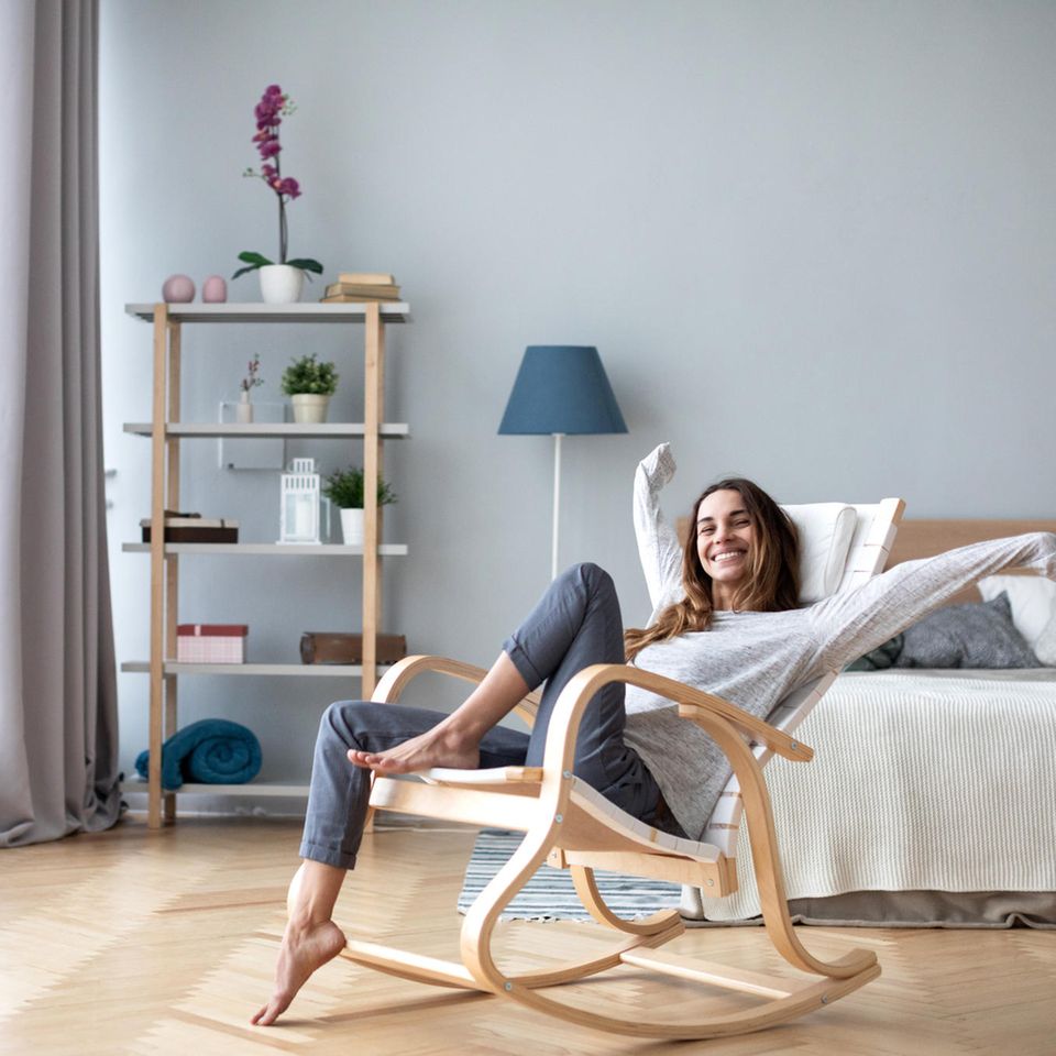 Glückliche Frau im Wohnzimmer: Diese 4 Interior-Tricks kosten keinen Cent, aber bringen viel