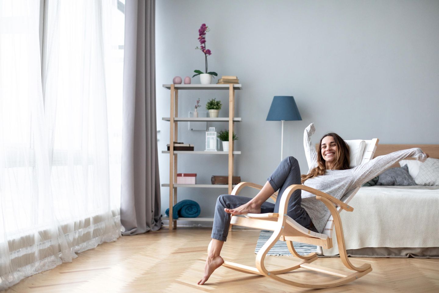Glückliche Frau im Wohnzimmer: Diese 4 Interior-Tricks kosten keinen Cent, aber bringen viel