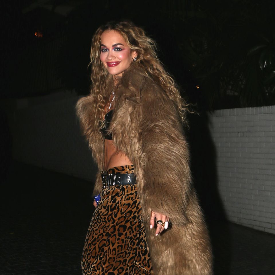 Auf dem Weg ins Luxus-Restaurant Chateau Marmont wird Rita Ora in einem Leo-Look abgelichtet. Die animalische Hose ergänzt sie mit einem Fax-Fur-Mantel und einem Leder-Bustier. Passend zu dem wilden Outfit trägt sie ihre langen Haare lockig.