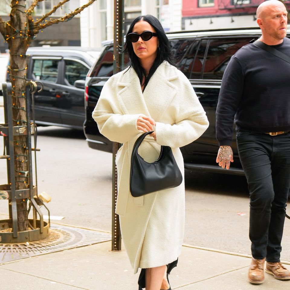 Katy Perry macht New York unsicher. Im weißen Kuschelmantel zeigt sie sich auf den Straßen Manhattans. Coole Accessoires in düsterem Schwarz sorgen für einen aufregenden Mix aus hell und dunkel.