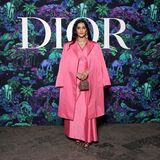 In einem pinken Duir-Ensemble nimmt Sonam Kapoor an der Dior-Fall-Show teil. Das drapierte Seidenkleid kombiniert sie trotz der hohen Temperaturen mit einem Mantel. Doch nicht nur die Farbe setzt ein Statement, auch das besetzte Dior Vanity Case sorgt für Aufmerksamkeit.