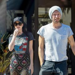 So glamourös das Leben von Dakota Johnson und Chris Martin auf den roten Teppichen dieser Welt auch aussieht, so herrlich normal scheint ihr Privatleben zu sein. Insbesondere, wenn es um einen Kaffee-Spaziergang geht. Denn hier zeigt sich das Paar von seiner sportlich-legeren Seite: Während Dakota auf eine bunt gemusterte Stoffhose, ein Shirt mit der Aufschrift "Born in the USA", Cap und ein Paar Converse setzt, trägt Chris eine Jogginghose, ein graues Shirt und eine Wollmütze.