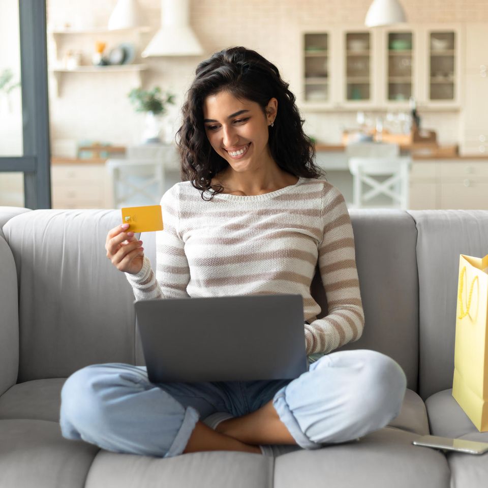 Amazon Prime Day: Glückliche Frau mit Kreditkarte und Laptop