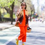 Im farbenfrohen Sommerlook läuft Olivia Palermo durch den Washington Square Park in New York. Das Model kombiniert ein orangefarbenes Set mit einer lässigen zweifarbigen Jacke mit Glitzersteinen. Für einen weiteren Farbtupfer sorgen die gelben Sneaker. Mit diesem trendigen Outfit macht sie die Straßen zu ihrem Laufsteg.