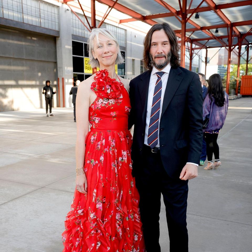 Auf der MOCA Gala in Los Angeles ziehen Schauspieler Keanu Reeves und seine Partnerin Alexandra Grant alle Blicke auf sich. Der Grund? Das Paar sieht einfach umwerfend aus. Während Alexandra auf ein Eyecatcher-Kleid mit Volants, Neckholder-Ausschnitt und Blumen-Print setzt, wählt Keanu für die Veranstaltung einen gut sitzenden Anzug mit gestreifter Krawatte. Nur die Wanderschuhe sorgen für einen ungewohnten Stilbruch, der nicht alle Geschmäcker treffen dürfte. 
