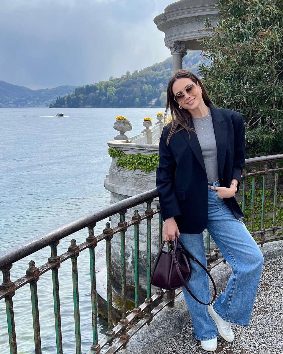 Gut gelaunt und sichtlich entspannt schlendert Mandy Capristo am Ufer des Comer Sees entlang. In lässiger Jeans, T-Shirt und Blazer schickt sie Urlaubsgrüße aus Italien. Highlight ihres Looks ist dabei die lilafarbene Bowling-Bag, mit der sie dem Outfit einen tollen Mix aus schlicht und edel verleiht.