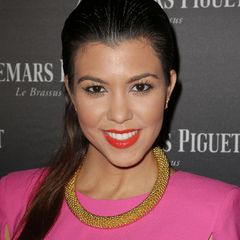 2013 erscheint Kourtney Kardashian in einem pinkfarbenen Cape-Kleid zu einem Event in Miami Beach. Ihr Make-up ist damals einfach gehalten: roter Lippenstift, viel Mascara, ein schwarzer Kajalstrich auf der Wasserlinie und etwas Bronzer, fertig. 