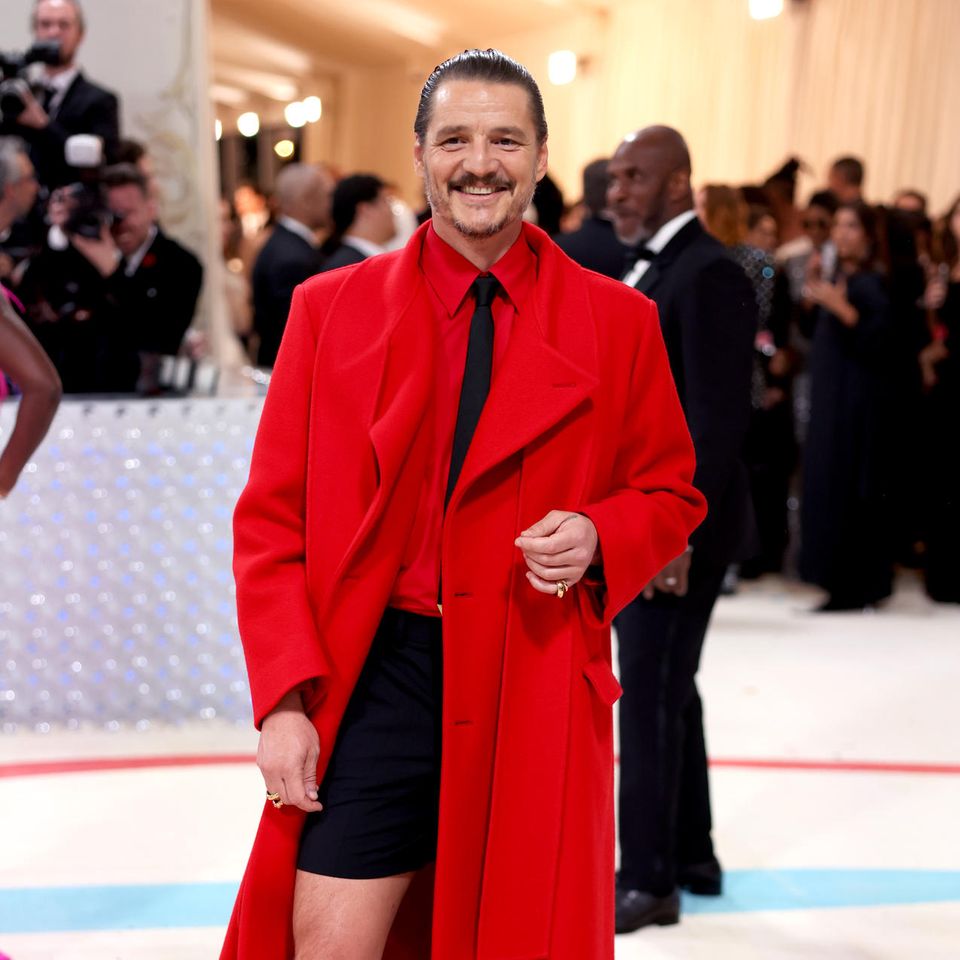 Im knallroten Valentino-Look zeigt Schauspieler Pedro Pascal Bein und scheint seinen großen Auftritt sichtlich zu genießen.