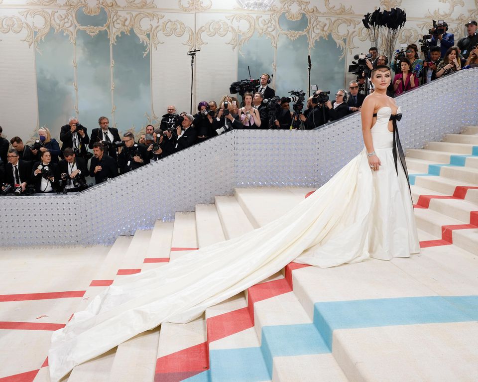 Met Gala 2023 : Vous pouvez toujours compter sur Florence Pugh pour la mode ! L'actrice enchante dans la robe en satin blanc de Valentino et surprend avec des cheveux rasés et un couvre-chef extravagant. Vous pouvez toujours compter sur Florence Pugh pour la mode ! L'actrice enchante dans une robe blanche de Valentino et surprend avec des cheveux rasés et un couvre-chef extravagant.