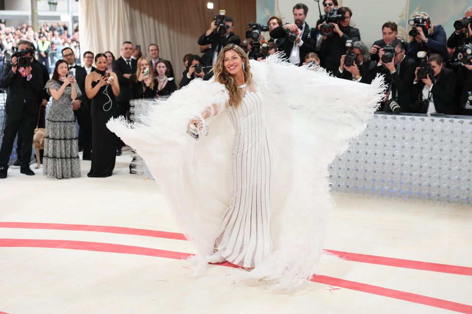 Quelle vue!  Le top model Gisele Bundchen brille dans sa robe blanche à cape frangée spectaculaire.