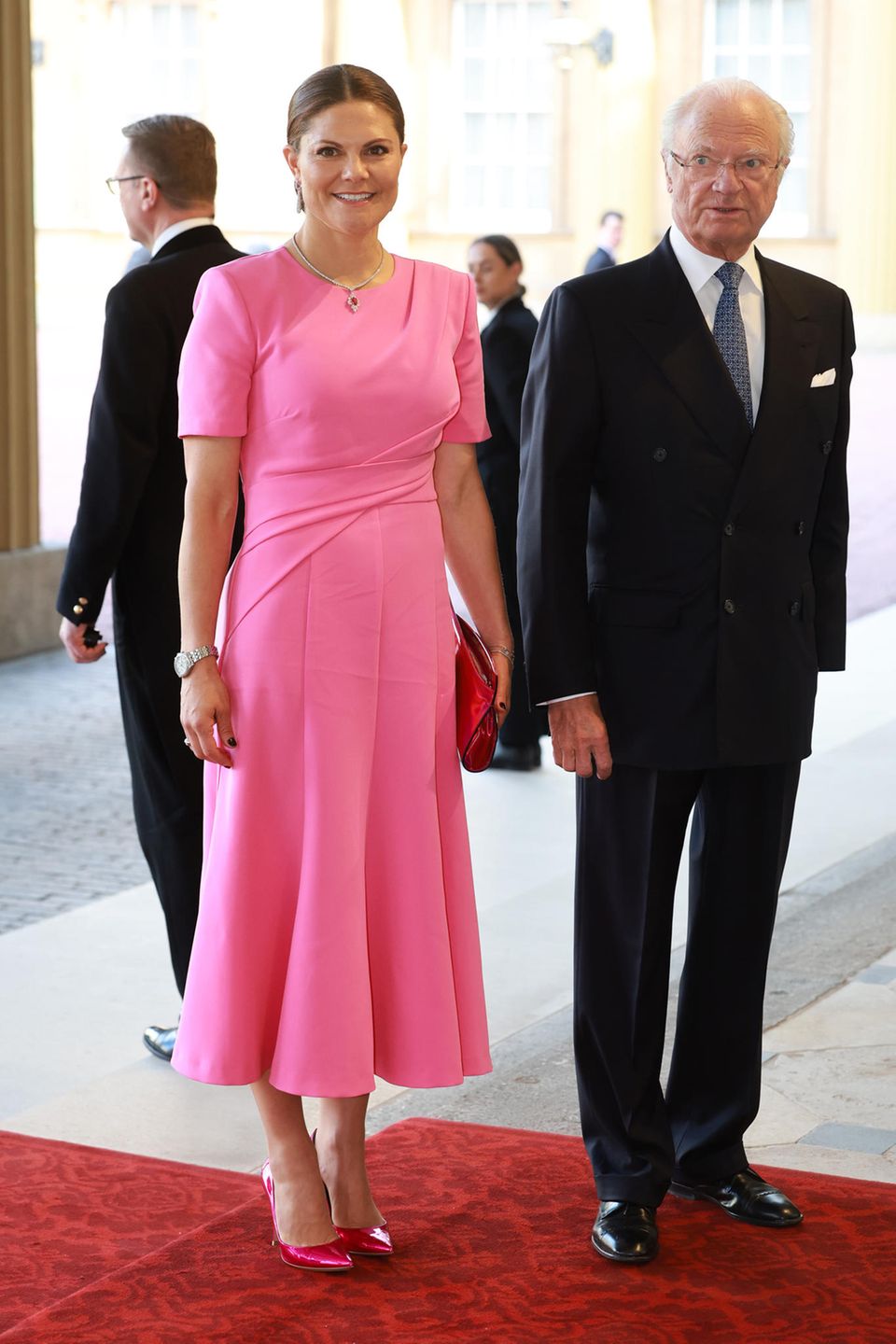 Kurz nach den norwegischen Royals, treffen die schwedischen Kolleg:innen ein: Prinzessin Victoria strahlt in einer rosafarbenen Robe, während Papa König Carl Gustaf sein gewohnt charmant-grimmiges Lächeln aufsetzt.