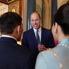 Prinz William ist beim Empfang gut aufgelegt und stößt mit den Gästen mit einem Glas Wein an.