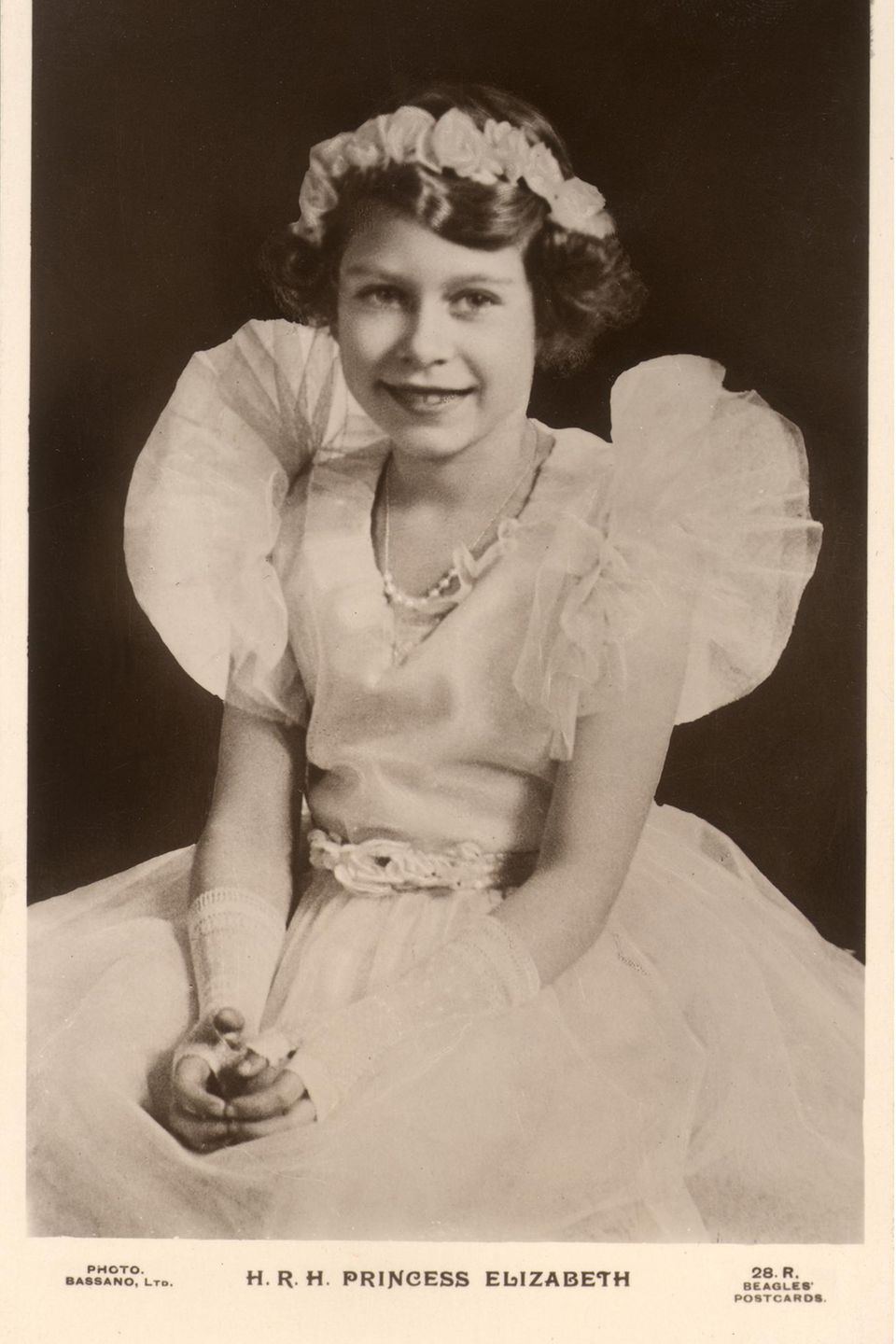 Die Ähnlichkeit ist unverkennbar. Dieses Foto aus dem Jahr 1935 zeigt Charlottes Urgroßmutter Queen Elizabeth (†96) mit Spitzenhandschuhen und einem gerüschten Chiffonkleid. Wie Prinzessin Charlotte trug auch die kleine Elizabeth in jungen Jahren eine Kopfbedeckung im floralen Design.