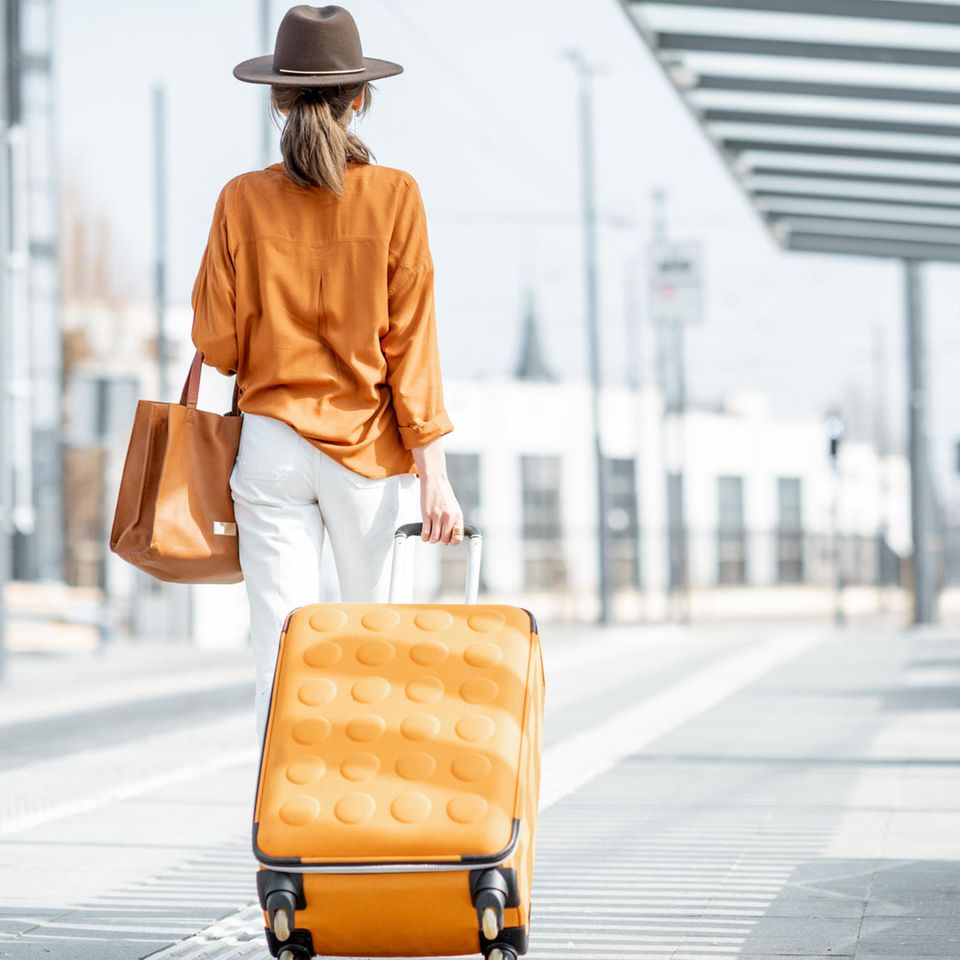 Eine Frau mit ihrem Koffer am Flughafen