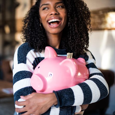 Glückliche Frau mit Sparschwein | Finanz-Horoskop: Diese 3 Sternzeichen denken nur ans Geld