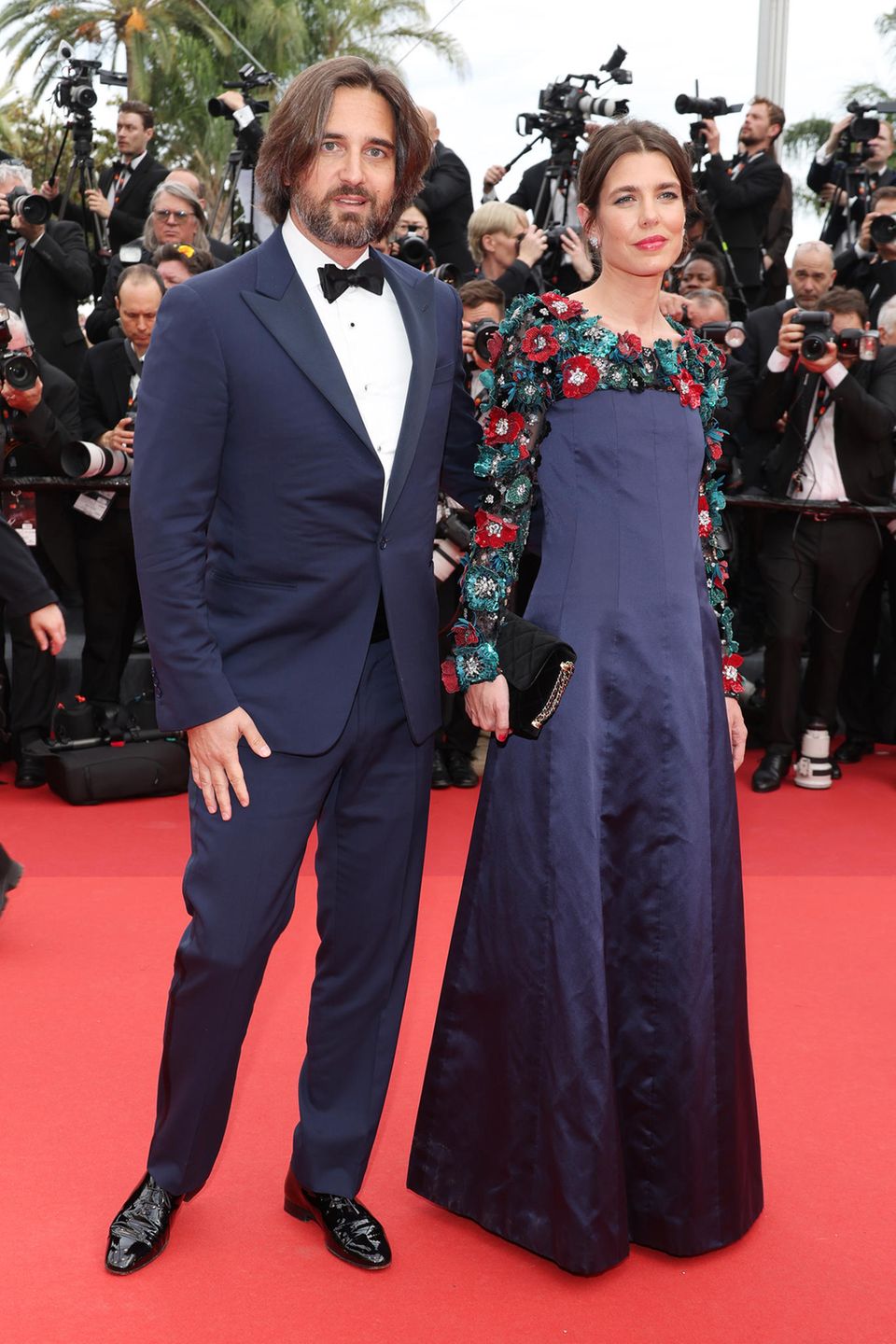 Charlotte Casiraghi zeigt sich gemeinsam mit Ehemann Dimitri Rassam auf dem roten Teppich der Filmfestspiele in Cannes. Während Charlotte auf ein mitternachtsblaues Kleid mit 3D-Blütenapplikation setzt, verzichtet Dimitrit zwar auf Blüten und Blumen, zeigt sich aber ebenfalls in dem dunklen Blauton.