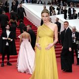 Red-Carpet-Göttin mit Babybauch: Karlie Kloss verzaubert die Gäste in Cannes in einem senfgelben One-Shoulder-Look von Dior und Schmuck von Chopard.