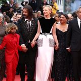 Cate Blanchett schreitet in Cannes mit all ihren Film-Kolleg:innen über den roten Teppich. Ihr weißes Kleid mit schwarzem Cape und Glitzertaschen von Louis Vuitton sticht bei dem Auftritt besonders hervor. 