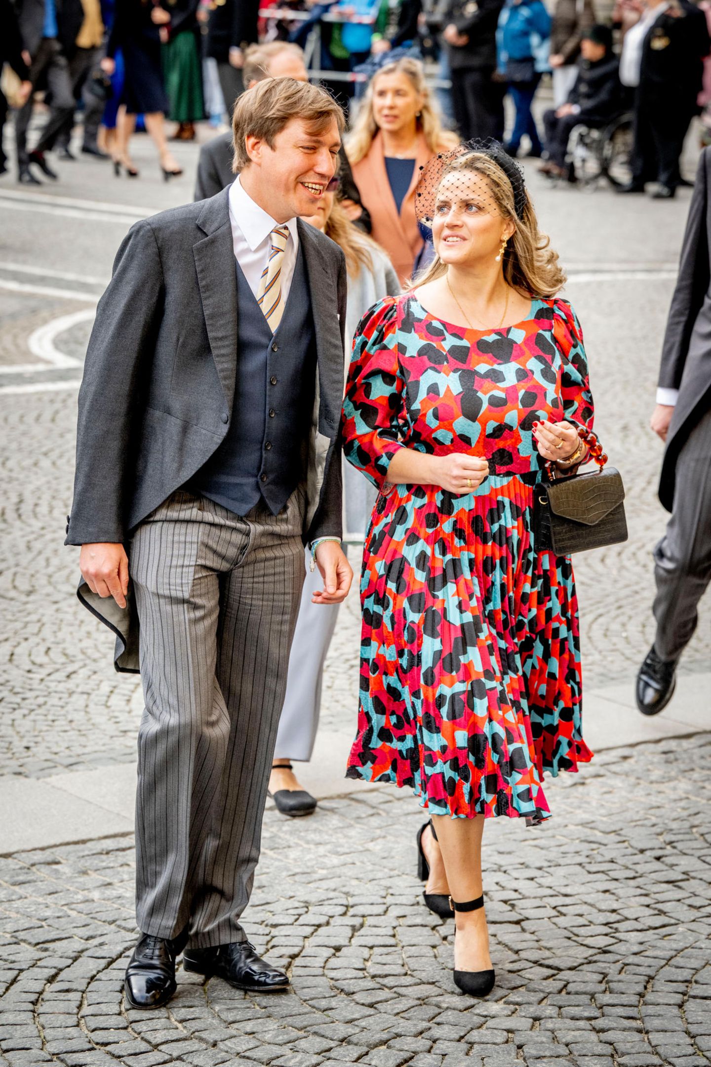 Prinz Louis von Luxemburg gehört ebenfalls zu den Gästen. Er unterhält sich angeregt mit seiner Begleitung Maria Gabriela de Orleans e Bragança, die in einem gemusterten Kleid zur Trauung kommt. 