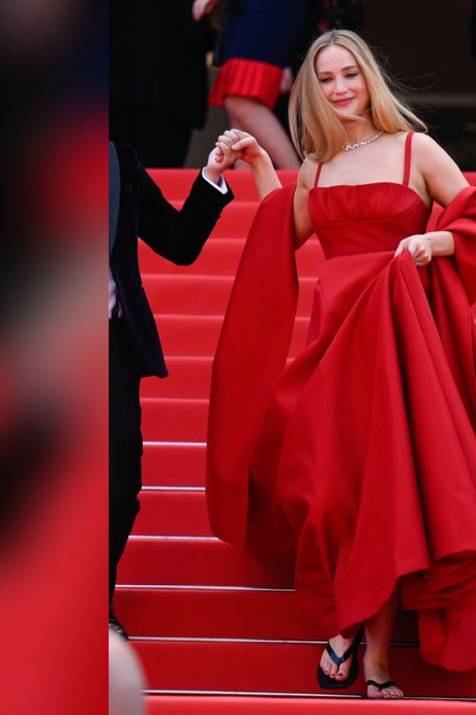 Jennifer Lawrence mit Abendkleid und Flip-Flops auf dem roten Teppich in Cannes.