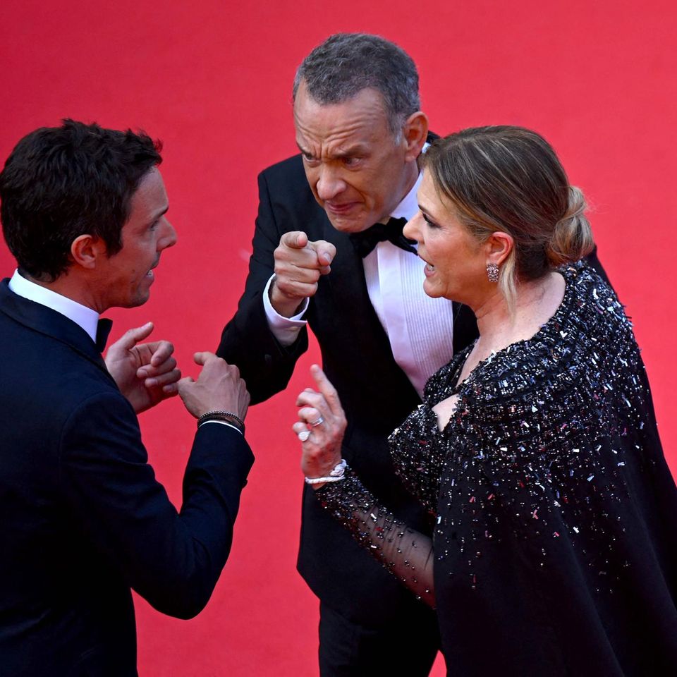 Tom Hanks und Ehefrau Rita Wilson im hitzigen Gespräch mit einem Mitarbeiter auf dem roten Teppich in Cannes.