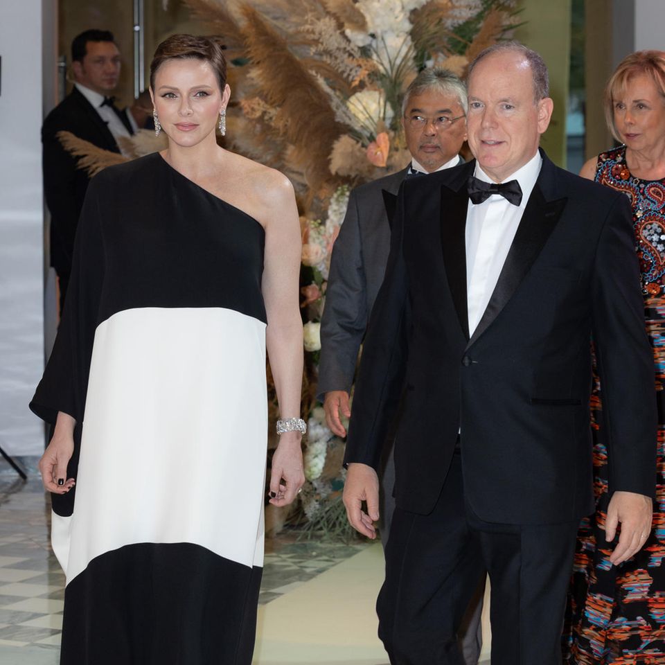 Denn auch Fürstin Charlène wählt eine auffällige Robe in Schwarz-Weiß. Ihr One-Shoulder-Dress von Valentino kostet um die 10.200 Euro. Dazu kombiniert die Frau von Fürst Albert auffällige Ohrringe und lackierte Fingernägel in Schwarz. 