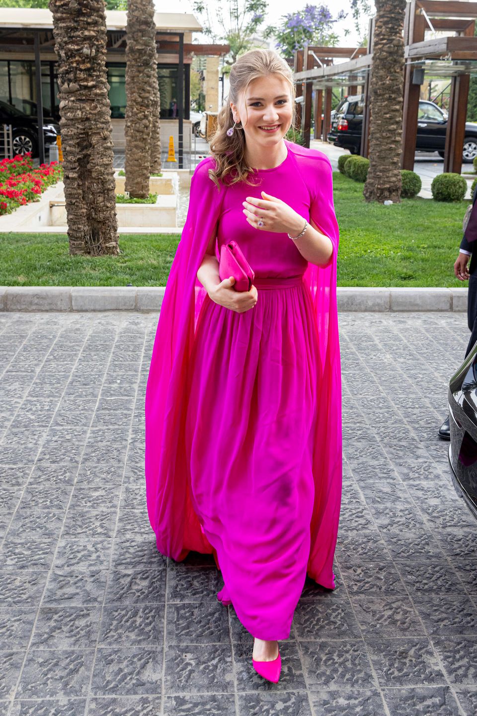 Fröhlich zeigt sich Kronprinzessin Elisabeth von Belgien in fuchsiafarbener Robe von Essentiel Antwerp. Ihr elegantes Kleid besticht jedoch nicht nur durch die lebhafte Farbe, vor allem die Cape-Ärmel verleihen ihrem Look einen raffinierten Touch.