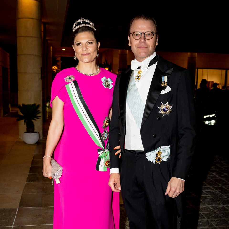 Beim Staatsbankett im Al Husseiniya-Palast nach der Trauung wird es noch einmal schicker! Kronprinzessin Victoria entscheidet sich für strahlendes Rosa. Ähnlich wie eng anliegenden Kleid mit Mini-Cape-Einsatz von Safiyaa strahlt auch ihr zweireihiges Diadem. Prinz Daniel erscheint im klassischen Smoking mit weißer Fliege. 