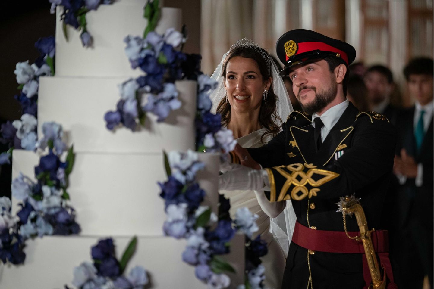 Prinzessin Rajwa und Prinz Hussein von Jordanien schneiden ihre Hochzeitstorte an.r