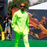 Auffallen kann Lewis Hamilton nicht nur mit sportlicher Leistung! In neongrüner Hemd-Hosen-Kombination von Versace zeigt sich der Formel-1-Fahrer am Rande der Rennstrecke in Barcelona und bereitet sich auf den nächsten Grand Prix vor. Dazu kombiniert der Modeliebhaber eine coole schmale Sonnenbrille und Boots mit eckiger Zehenpartie.