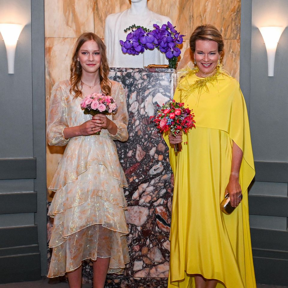 Hier ist das Kleid von Königin Mathilde offensichtlich perfekt an ihren Gemütszustand angepasst: Im sonnigen Gelb zeigt sich die Belgierin gemeinsam mit ihrer jüngsten Tochter Prinzessin Eléonore beim dritten Finale des Königin Elisabeth Wettbewerbs für Gesang in Brüssel und strahlt dabei über beide Ohren. Zu dem verspielten Kleid mit Federn kombiniert Mathilde goldene Riemchen-Stilettos sowie eine goldene Clutch und zarten Schmuck. Eléonore adaptiert das Gelb, wählt jedoch ein Kleid in einer deutlich zarteren Farbvariante. 
