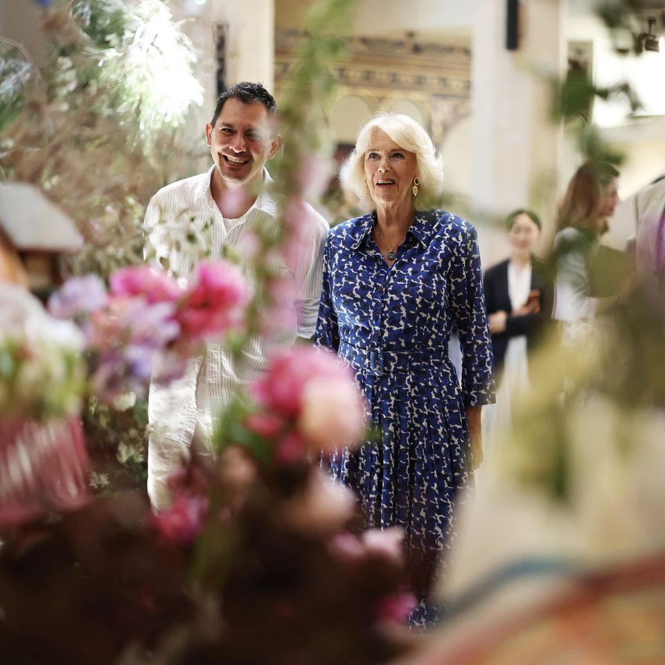 Bei ihrem Rundgang zeigt sich Königin Camilla begeistert von der Blütenpracht im Garden Museum.  