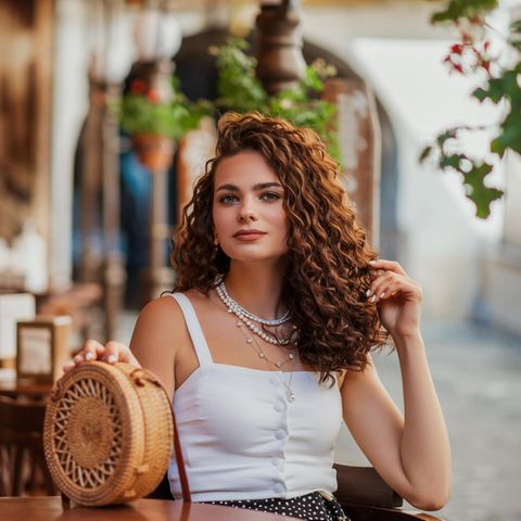 Frau mit sommerlichem Styling und Schmucktrend Multi-Chains.