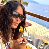 Eine Paella mit Aussicht! Salma Hayek genießt das Nationalgericht der Region Valencia in einem Restaurant, dessen Ausblick nicht besser sein könnte. Direkt am Meer, frischer Fisch, dazu Reis und Gemüse – wir wünschen Guten Appetit!
