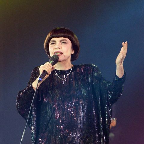 Schwarzes Kleid, Pagenfrisur, erhobene Hand: Mireille Mathieu steht noch auf der Bühne wie vor 50 Jahren.